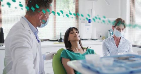 Dentist reassuring patient during dental examination in modern clinic