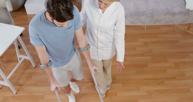 Physical Therapist Assisting Man with Crutches in Rehabilitation Center - Download Free Stock Images Pikwizard.com