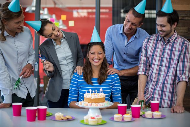 Group of colleagues enjoying a birthday celebration at the office. Ideal for depicting workplace culture, team bonding, and corporate events. Great for use in articles about work-life balance, team spirit, and office celebrations.