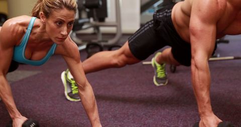 Determined Athletes Performing Plank With Dumbbells in Gym - Download Free Stock Images Pikwizard.com