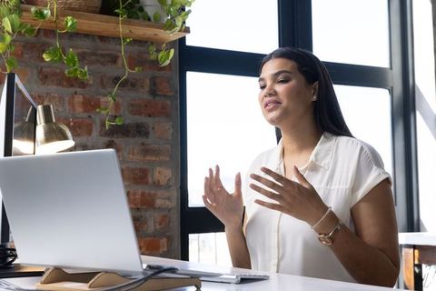 Hispanic woman communicating online in modern home office