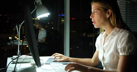 Focused Businesswoman Working Late in Office Nighttime