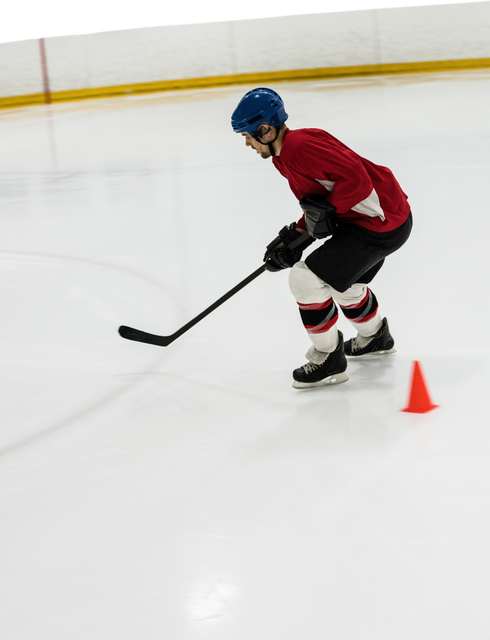 Ice hockey player wearing red jersey and blue helmet skating with stick in hand during training session on an ice rink. Useful for sports related content, athletic training articles, promoting ice hockey gear or illustrating teamwork and athletic skills.