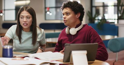 Campus Study Collaboration with Tablet, Headphones and Textbooks Featuring African American Peer