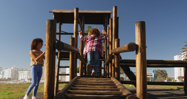 Mother Watching Child Climbing at Outdoor Playground, Urban Background - Download Free Stock Images Pikwizard.com