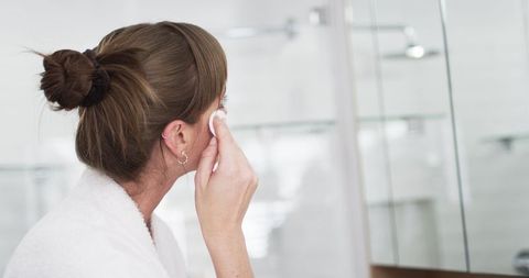 Woman Practicing Relaxing Skincare Routine in Home Bathroom