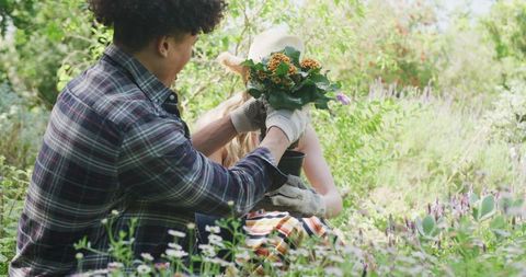 Happy couple gardening and planting together in lush garden