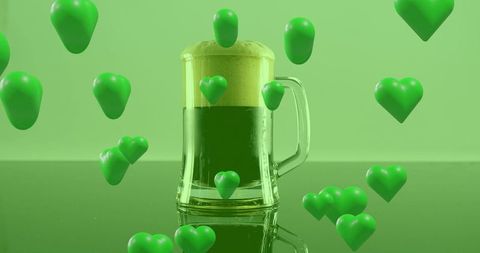 Green beer mug with floating heart icons and frothy foam on glossy surface
