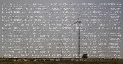 Wind turbine with binary code overlay representing renewable energy data and smart grid