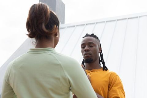 African american couple meditating on rooftop terrace, urban mindfulness and connection