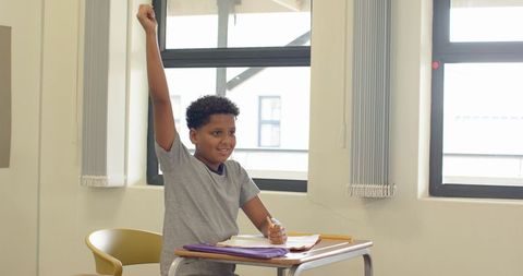 Schoolchild raising hand in active classroom participation
