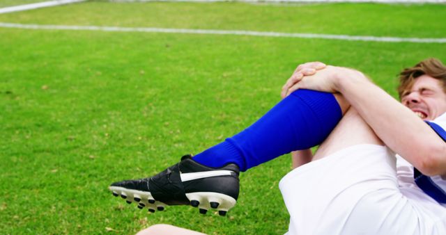 Soccer Player Lying on Field in Pain Holding Leg - Download Free Stock Images Pikwizard.com