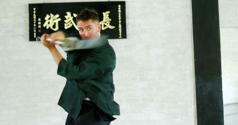 Caucasian Man Practicing Martial Arts in Traditional Dojo