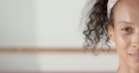 Elegant dancer stretching by ballet barre in studio