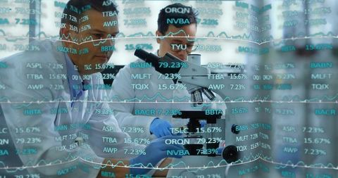 Scientists collaborating at microscope while visualizing data overlays and analytics
