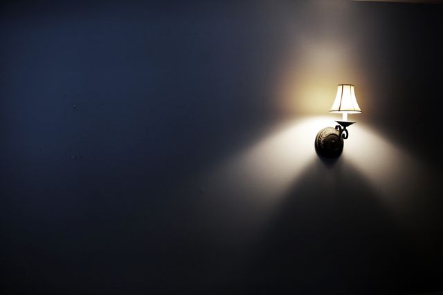Dimly Lit Wall Lamp Casting Warm Light in Dark Room - Download Free Stock Photos Pikwizard.com