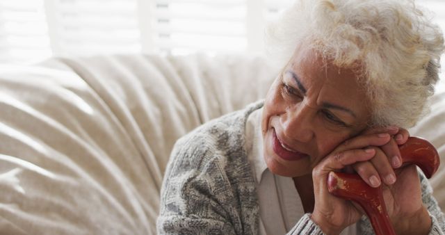 Senior Woman Relaxing on Couch with Walking Cane at Home - Download Free Stock Images Pikwizard.com