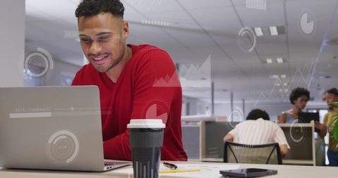 Businessman Using Laptop for Financial Analysis in Office