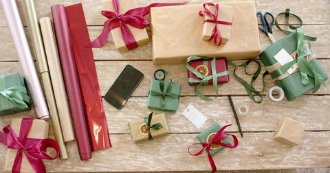 Handmade rustic gift wrapping with kraft paper, green ribbon, red satin bows and citrus
