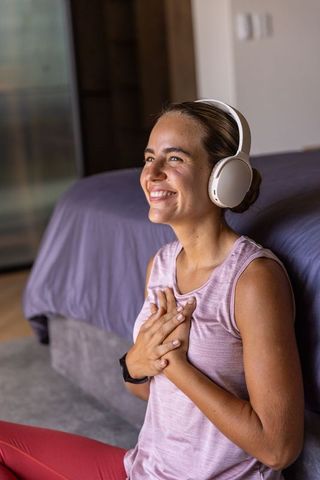 Young woman practicing mindfulness and gratitude listening to guided meditation headphones