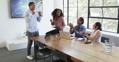 Diverse Colleagues Celebrating Success in Office Meeting