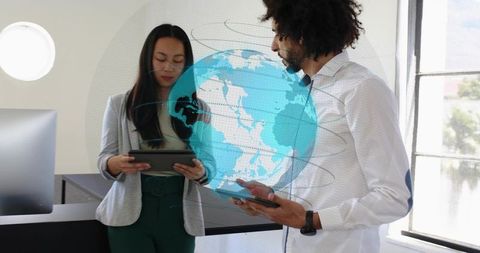 Business team collaborating with holographic globe and tablets in modern office