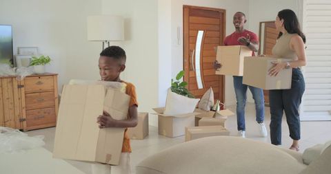 Family moving day unpacking boxes and smiling in bright modern living room