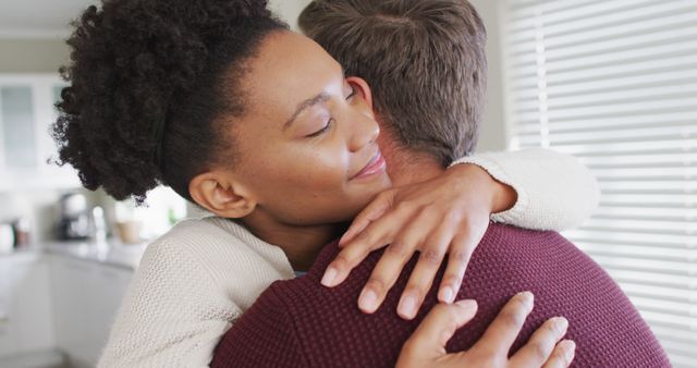 Image of happy diverse couple hugging in kitchen - Download Free Stock Photos Pikwizard.com
