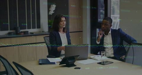 Business Duo Analyzing Data with Technology Overlays in Modern Office