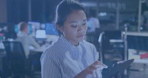 Focused Businesswoman Analyzing Data on Tablet in Office