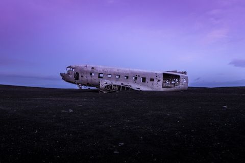 Abandoned plane crash  wreckage on solitary beach at twilight