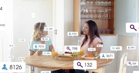 Chatting over breakfast at sunlit wooden table with social media ui overlays