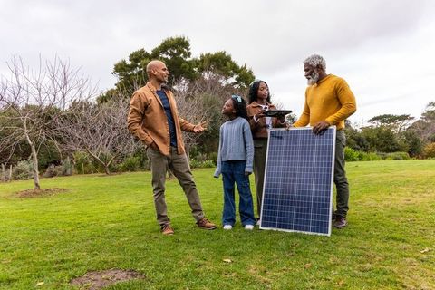 African american family installing solar panel during outdoor renewable energy lesson