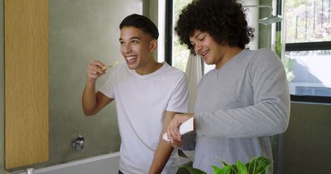 Joyful Friends Practicing Dental Hygiene in Modern Bathroom