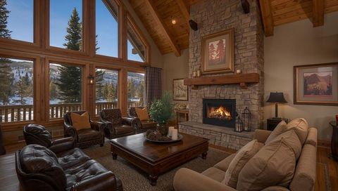 Cozy mountain lodge living room bathing in natural light, stone fireplace and rustic wood interior