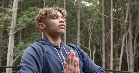 Mindful man meditating in peaceful forest environment