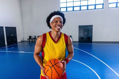 Athletic African American Man Smiling on Indoor Basketball Court