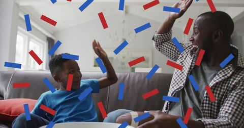 Father and Son Cheering with Confetti during Sports Game