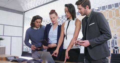 Diverse Business Team Collaborating with Digital Devices in Modern Office