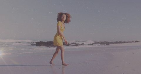 Carefree woman walking barefoot on sunny beach