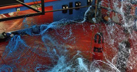 Swirling Fluid Simulation on Red Padded Mat in Demo Lab