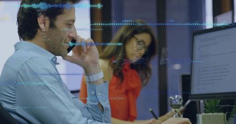 Team collaborating on code and data visualization using desktop monitor and mobile phone