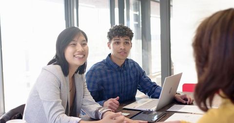 Team Meeting with Laptop and Documents in Modern Office