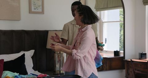 Multiracial couple enjoying wardrobe selection at home