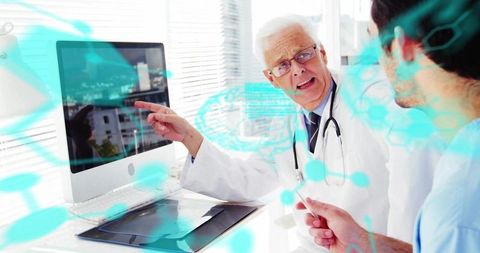Senior doctor pointing at monitor explaining clinical data to peer with digital overlay