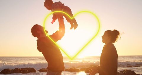 Happy Family Playing at Beach During Sunset