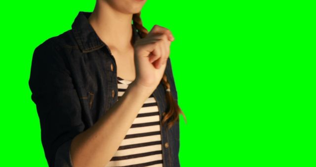 Mid section of woman using digital screen against green screen 