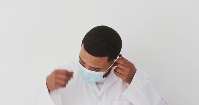 Medical Professional Putting on Protective Mask in White Coat - Download Free Stock Images Pikwizard.com