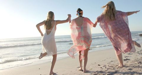 Carefree Women Joyfully Running Along Seashore
