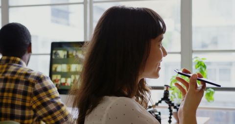 Businesswoman Engaging in a Telephonic Discussion in a Modern Office Space